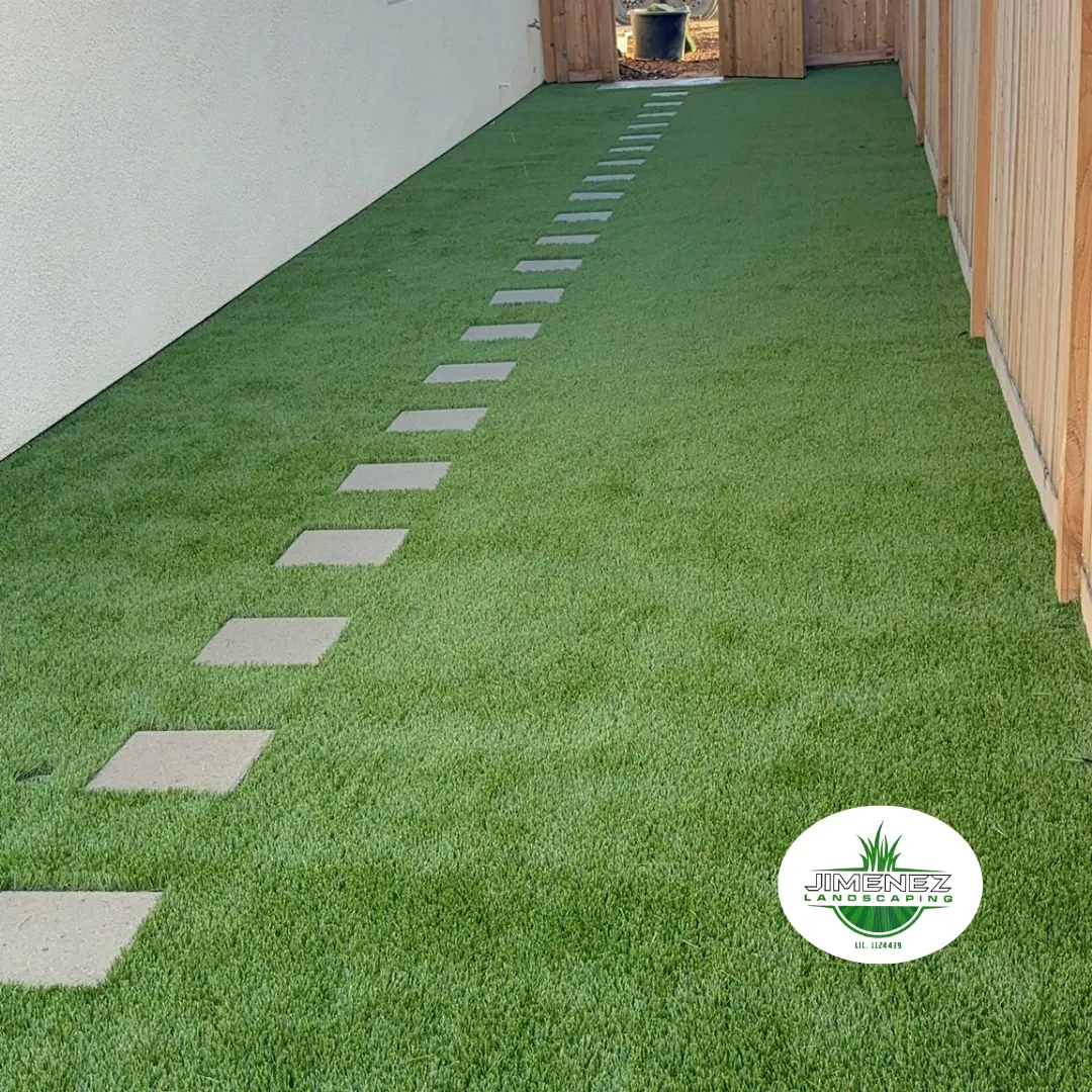 Artificial turf pathway with concrete stepping stones, showcasing a neat outdoor space designed by Jimenez Landscaping, serving Bakersfield and nearby areas.