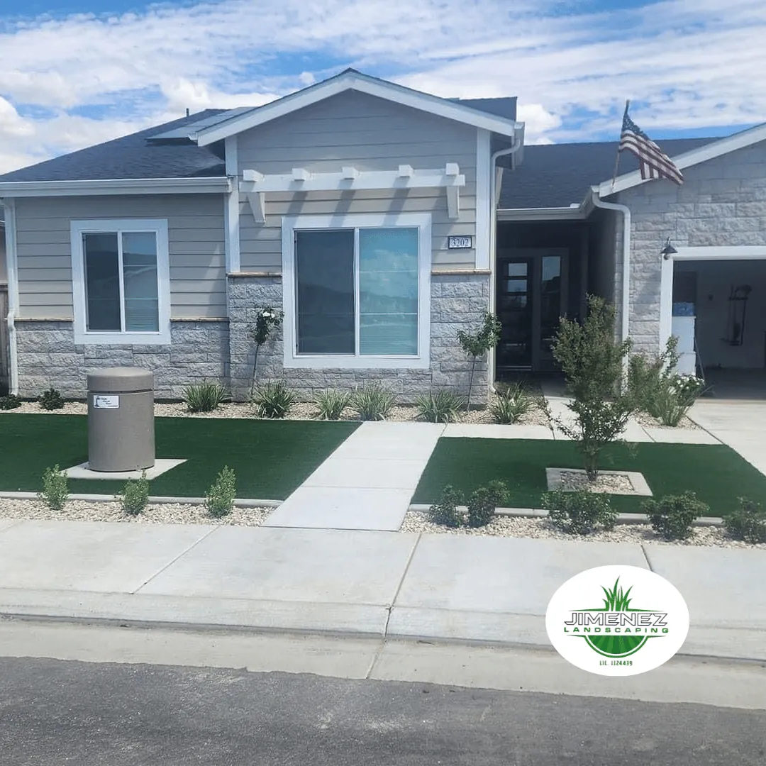 Modern home exterior in Bakersfield featuring artificial turf, decorative rocks, and low-maintenance landscaping, showcasing Jimenez Landscaping's design expertise.