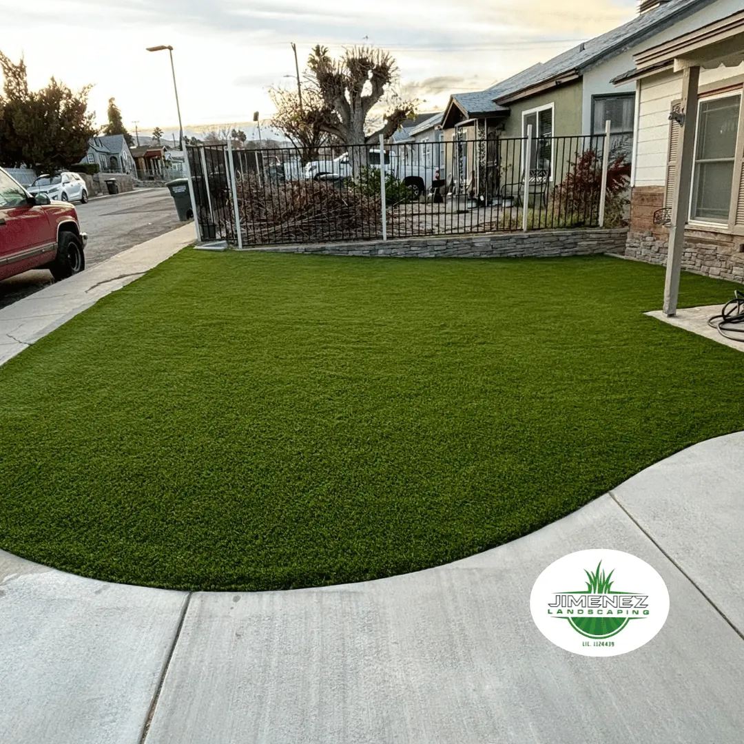Artificial turf installation in a lush green lawn, enhancing residential landscaping in Bakersfield, with Jimenez Landscaping logo visible.