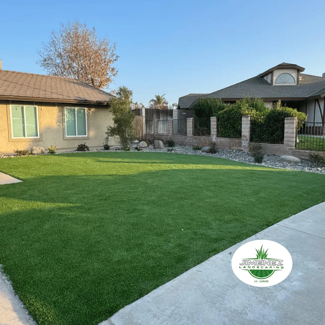 Vibrant artificial turf lawn in a Bakersfield home, showcasing a well-maintained outdoor space with decorative rocks and plants, emphasizing Jimenez Landscaping's expertise in landscape design and installation.