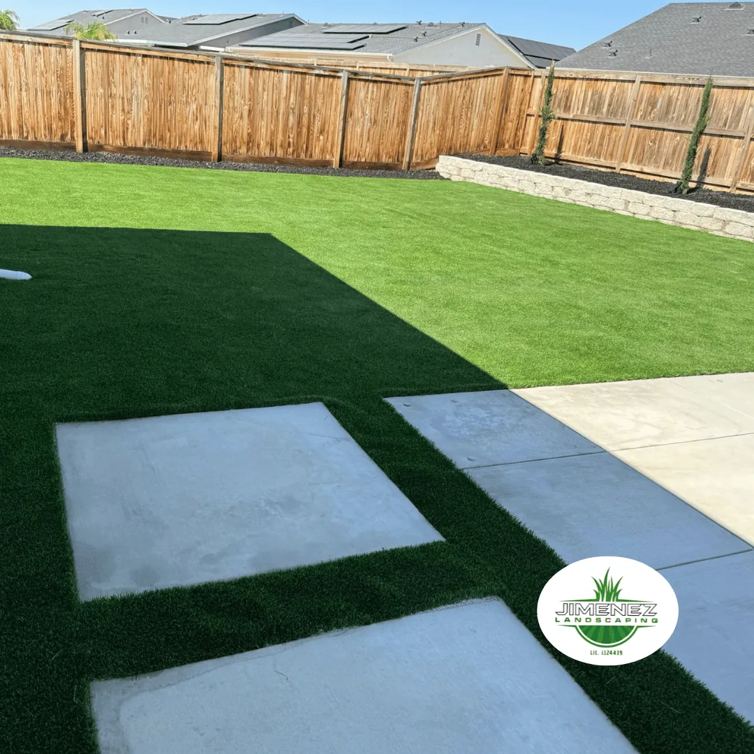 Low-maintenance artificial turf lawn with concrete stepping stones, designed by Jimenez Landscaping for a stylish outdoor space in Bakersfield.