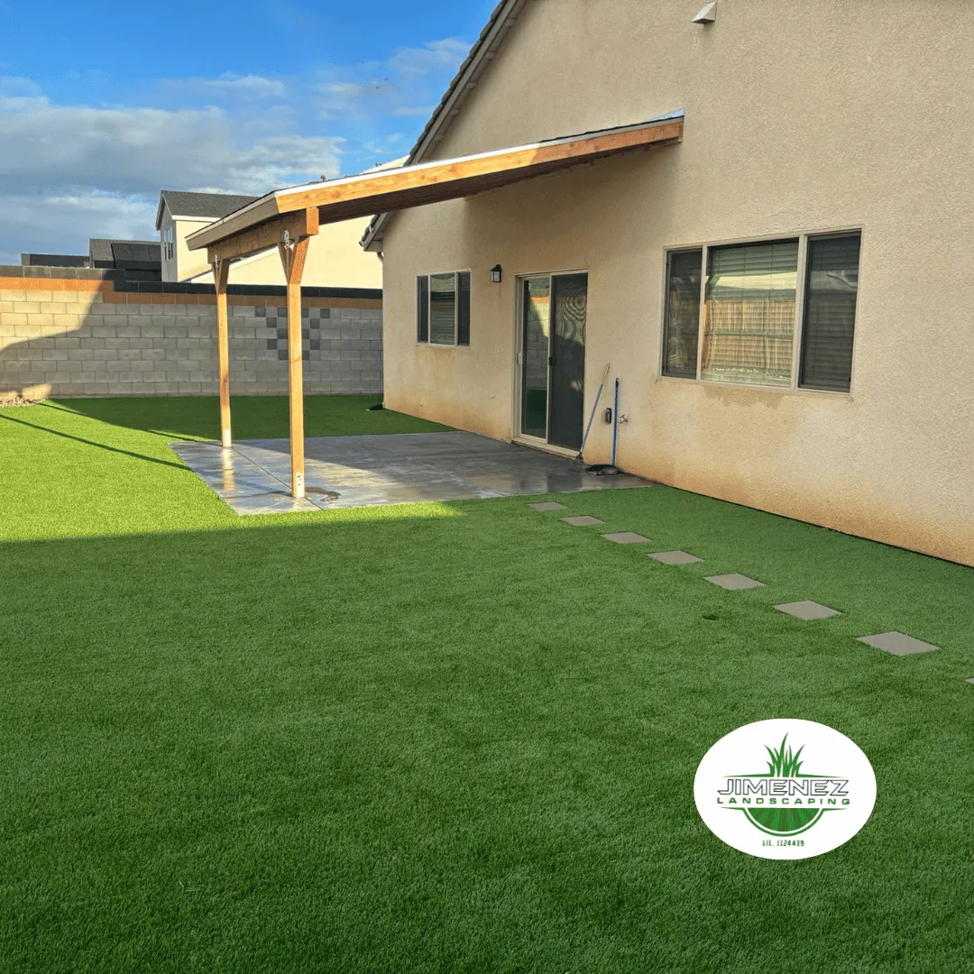 Backyard with artificial turf and a wooden pergola, showcasing a landscaped outdoor living space in Bakersfield.